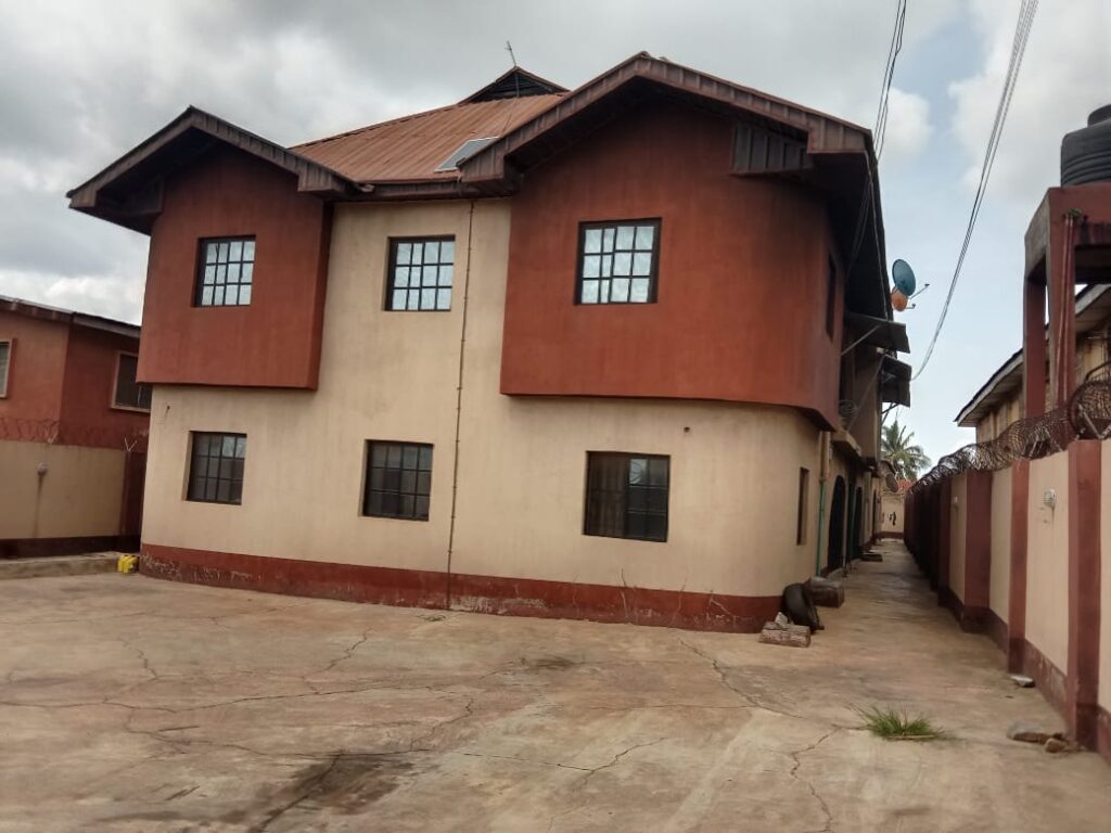 Front and side view of a residential property for sale at 127 Kosobo, Oyo Town, Oyo State, featuring 4 units of 3-bedroom flats and 1 unit of 2-bedroom bungalow on a 55ft by 164ft plot of land.